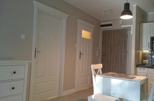 eine Küche mit einem Tisch und einem Stuhl in einem Zimmer in der Unterkunft Apartament 20 in Dziwnówek