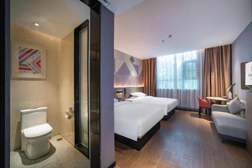 WuzhouにあるBorrman Hotel Wuzhou College Fumin Roadのベッドとバスルームがあるホテルの部屋