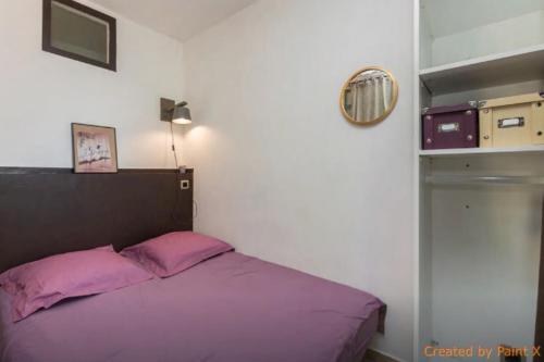 a bedroom with a purple bed and a shelf at Auberge la Tuilerie in Violès