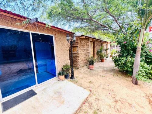 a brick house with a large window and potted plants at Villa Anaschansu in Ríohacha