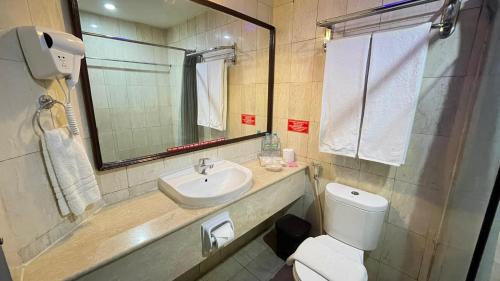 a bathroom with a sink and a toilet and a mirror at The Tandibayang Hotel & Villas in Badung