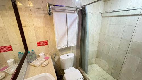 a bathroom with a shower and a toilet and a sink at The Tandibayang Hotel & Villas in Badung