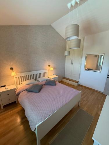 a bedroom with a large bed with purple sheets and pillows at Villa Maluso in Budva