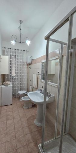 a bathroom with a sink and a toilet and a mirror at Casa vacanze La Commare in Forme