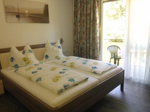 a bedroom with a bed with blue and white sheets and a window at Appartements Waldhof in Sankt Kanzian