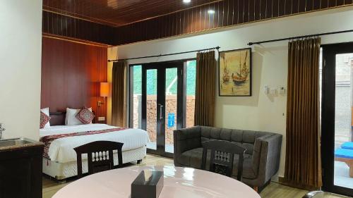 a bedroom with a bed and a couch and a table at The Tandibayang Hotel & Villas in Badung