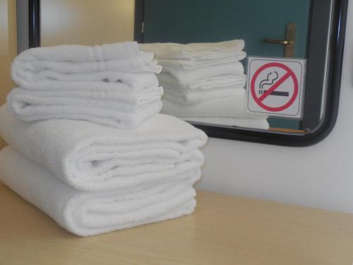 a stack of towels sitting on a table in front of a mirror at Hotel Prestige in Lido di Camaiore
