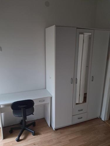 a white desk with a chair next to a cabinet at Lola Jagodina in Jagodina