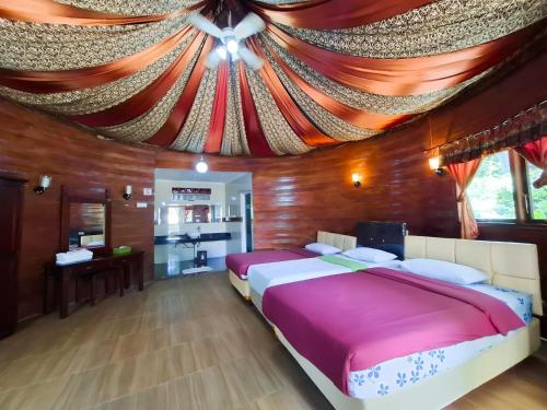 ein Schlafzimmer mit einem großen Bett mit Decke in der Unterkunft Green Valley Resort Bandungan in Bandungan