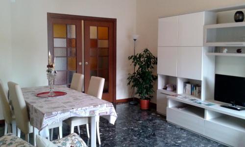 ein Esszimmer mit einem Tisch mit Stühlen und einem TV in der Unterkunft Cristina Apartment in Verona