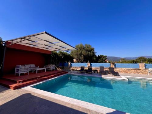 una piscina con un padiglione sopra di ΒΙΛΛΑ ΤΟ ΠΕΤΡΙΝΟ stone bild villa full equipment a Nafpaktos