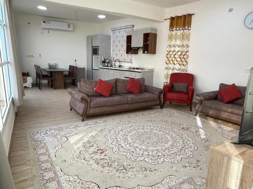 a living room with two couches and a kitchen at Samail Valley in Samail