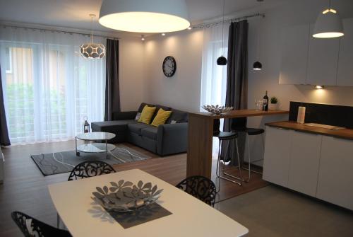a kitchen and living room with a couch and a table at Magnolia Centrum - free parking in Wrocław