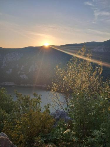 a view of the sun setting over a lake at Cabanutele La Denisa in Dubova