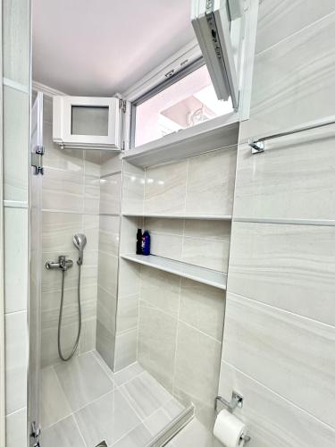 a bathroom with a shower and a window at Aiginetan Apartments in Aegina Town