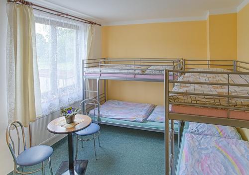 Stružná的住宿－Pension Jezdecké centrum Kočík，客房设有两张双层床和一张桌子及椅子。