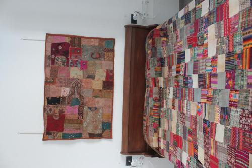 a quilt hanging on a wall next to a mirror at B&B Monterosso in Realmonte