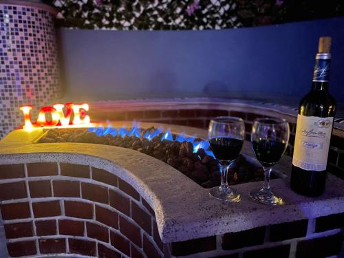 two glasses of wine next to a brick fire place at Modern, Luxurious and Tradicional Apartments by Samilis Place in Cali