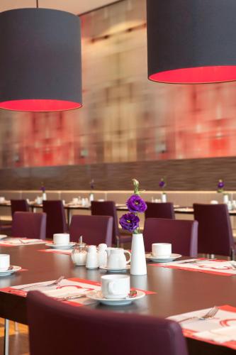 a dining room with a table with purple flowers on it at IntercityHotel Berlin Hauptbahnhof in Berlin