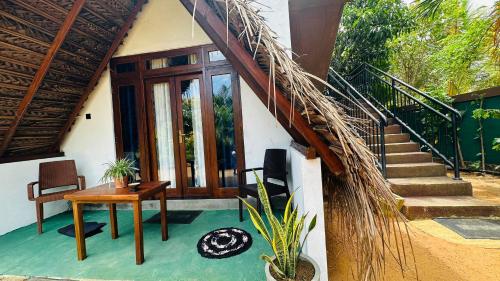 a house with a staircase and a table and a stair case at Dew Ashi Homestay in Sigiriya