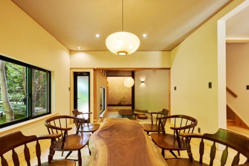 a dining room with a table and chairs at 高尾山すぐ貸切villa都心から70分自然豊か貸切サウナ道志ツーリングBBQ焚火花火日本庭園 in Sagamihara