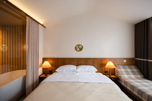 a bedroom with a large bed and a bath tub at hotel hommtown chiang mai in Chiang Mai