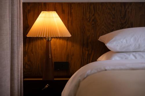 a lamp sitting on a table next to a bed at hotel hommtown chiang mai in Chiang Mai
