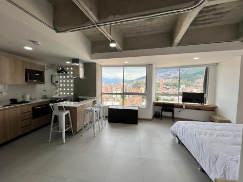a bedroom with a bed and a kitchen with a view at Edificio Aiana Verde by Host Medellin in Medellín