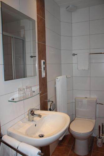 a white bathroom with a sink and a toilet at Haus Margit in Ramsau am Dachstein
