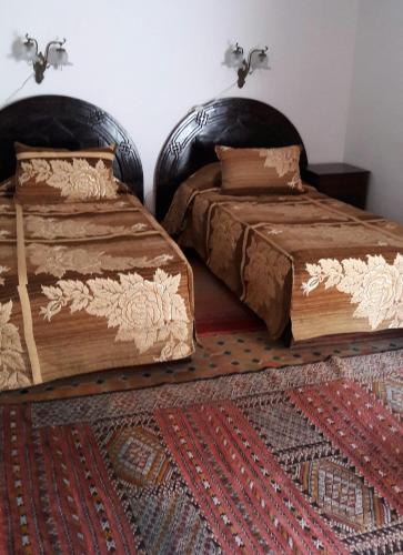 two beds sitting next to each other in a room at Dar El Mouhit in Sale