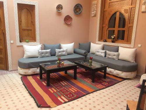 sala de estar con sofá azul y 2 mesas en Riad Jenan Adam, en Marrakech