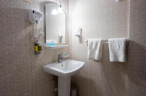 a bathroom with a sink and a mirror and towels at فندق اعالي الحجاز in Makkah