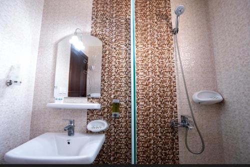 a bathroom with a sink and a shower with a mirror at فندق اعالي الحجاز in Makkah