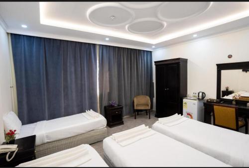 a hotel room with two beds and a desk at فندق اعالي الحجاز in Makkah