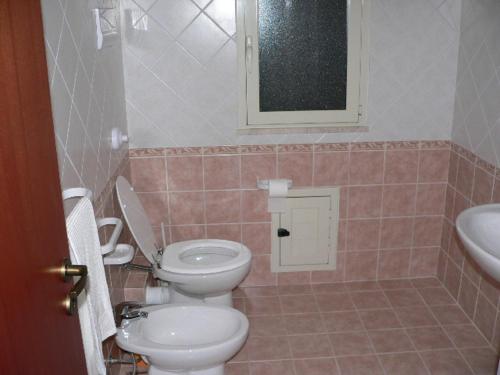 a bathroom with a toilet and a sink and a mirror at Il Noce Antico in Bisacquino