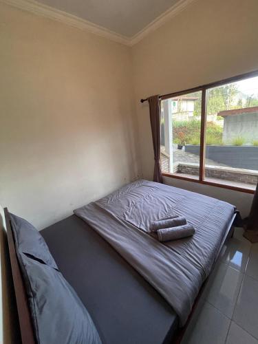 a bed in a room with a window at Ikiikahomestay in Probolinggo
