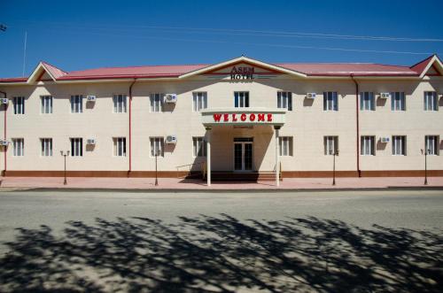 a white building with a sign that reads virgin at Asem Hotel in Nukus