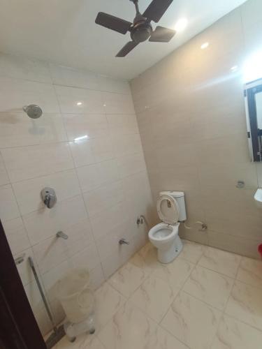 a bathroom with a toilet and a shower with a ceiling at Hotel JP International in Katra