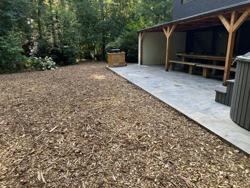 a patio with a picnic table next to a building at Glampingtent Bosgenot in Zedelgem