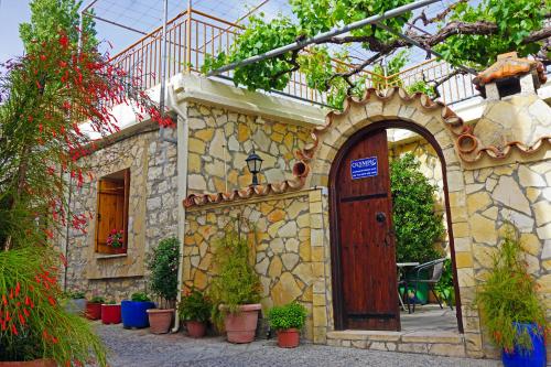 a building with an arch and a door with potted plants at Omodos Village Houses in Omodos
