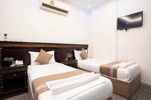 a hotel room with two beds and a television at فندق اعالي الحجاز in Makkah