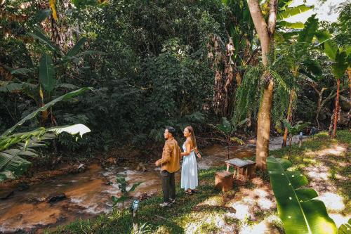 a man and a woman standing in a forest at ภูธารา กลางดง in Ban Thung Phan Ha