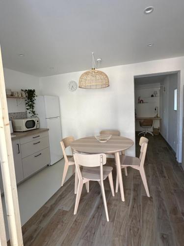 une cuisine avec une table et des chaises dans une pièce dans l'établissement Au Puy de Paugnat, à Charbonnières-lès-Varennes