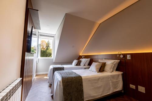 a bedroom with two beds and a window at Novo Bhaus Gaudi Campos do Jordão Loft Duplex - Linda Vista - 600m do Capivari in Campos do Jordão