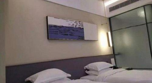 a hotel room with two beds and a mirror at AURAYA BY SUNING NANJING XUZHUANG in Nanjing