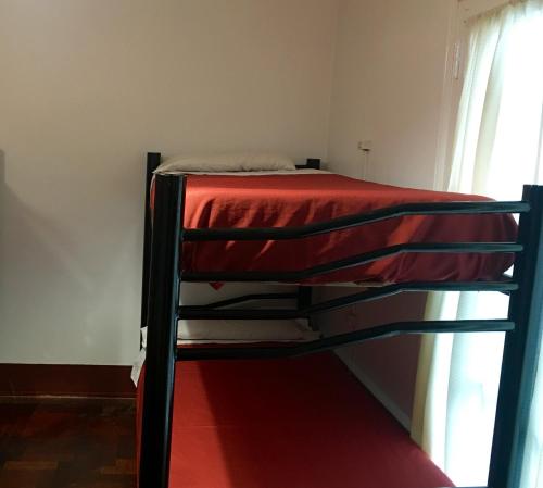 a bunk bed in a room with a red blanket at Hostel Lagares in Mendoza