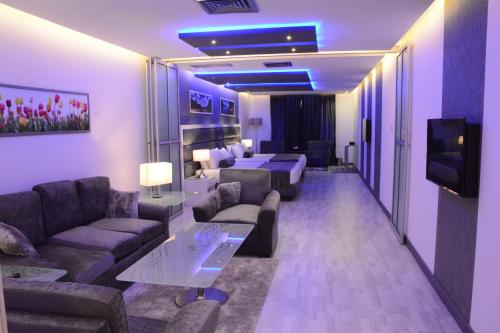 a living room with couches and a tv in a room at Islamabad Hotel in Islamabad