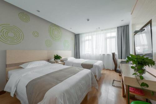 a hotel room with two beds and a window at GreenTree Inn Wuhu Eshan Road University City in Wuhu
