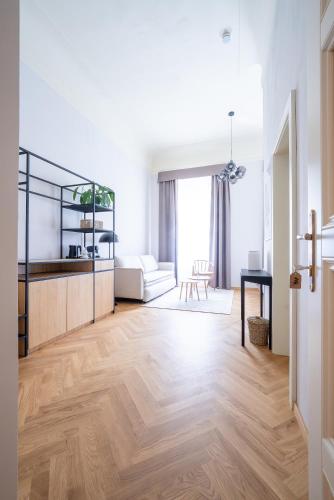 a living room with a white couch and a wooden floor at Zámek Načeradec in Načeradec