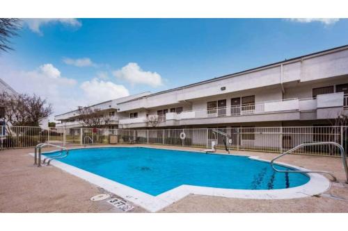 a swimming pool in front of a building at Studio 6 Irving, TX - Irving DFW Airport East in Irving